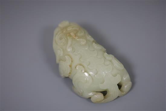 A Chinese pale celadon jade figure of lion-dog, bixi, 17th century, L. 6.8cm, wood stand